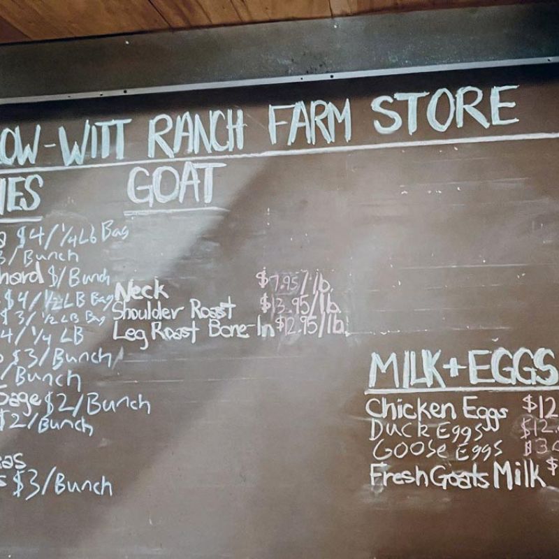 Farm Store chalkboard sign listing available organic produce, fresh goat milk and eggs