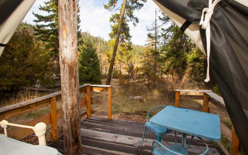 Inside Raven wall tent looking outdoors to deck with table and chairs