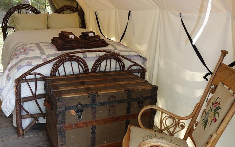 Redwing wall tent interior with rocking chair, storage chest, and two double beds