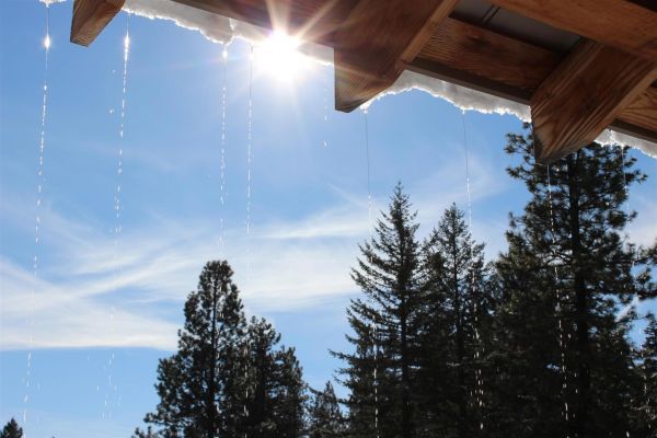 icicles on farmhouse with blue January sky