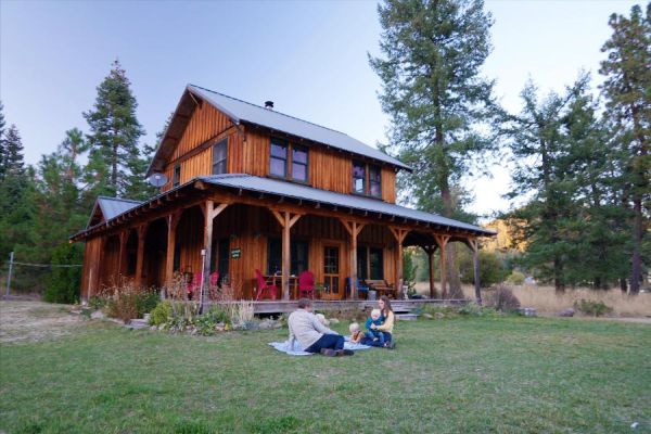 Meadow House farm stay with young family on blanket on front lawn enjoying the evening together