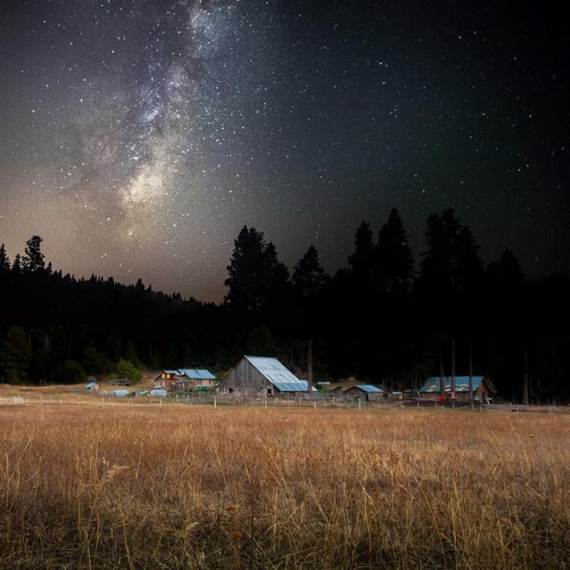 Milky Way appears brightly over farm buildings in the fall