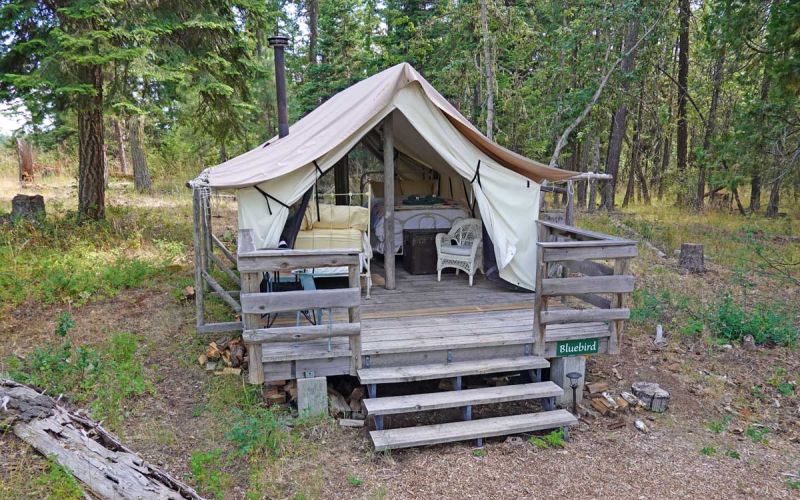 Bluebird wall tent exterior has deck with table and chairs